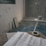 Renover une salle de bain : salle en chantier avec sol protégé et douche à l’italienne