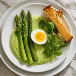 Entrée pâques gastronomique : asperges vertes et œuf parfait sur crème de petits pois